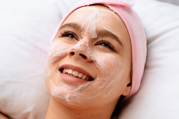 Woman relaxing with face bubble cleansing mask during skincare treatment in beauty salon