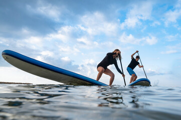 Water sport fun: couple racing on paddleboards