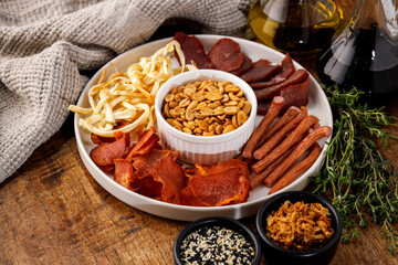 Assorted beer snacks platter with smoked cheese, sausages and peanuts