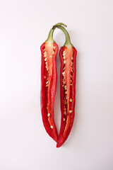 Halved chili pepper placed on a white background.