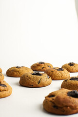 Flat lay of homemade soft chocolate chunk cookies on white background. Delicious golden brown cookies perfect for dessert, snack, or bakery menu.