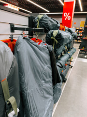 Outdoor equipment for camping displayed on shelves in a retail store during a sale event