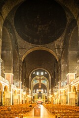 Interior view of Westminster Cathedral with illuminated columns and arched ceiling during evening...