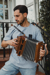 Man Playing Accordion Outsdide His House 