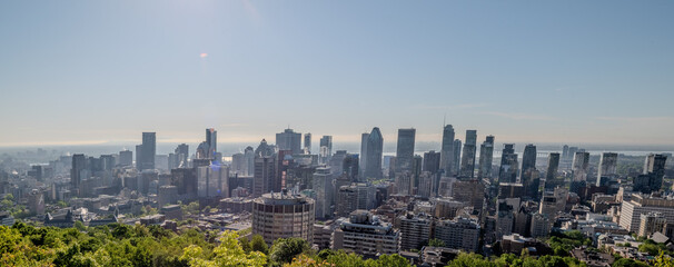 Scenic view of Montreal's skyline showcasing its diverse architecture, with lush green trees in the...