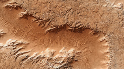 Aerial view of desert landscape with sand dunes and rocky terrain showing natural patterns and textures in warm brown tones