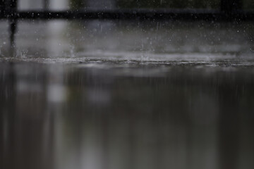 heavy raining make many small splash crown from water droplets drop down to the concrete floor in blue tone color scene