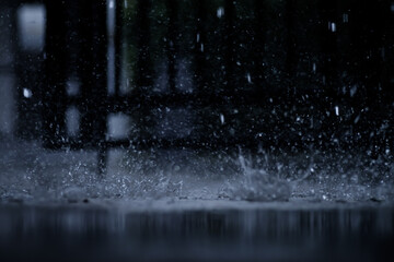 heavy raining make many small splash crown from water droplets drop down to the concrete floor in blue tone color scene