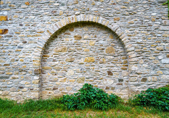 old stone wall with arch create a frame with blank space, close up of beautiful and cozy...