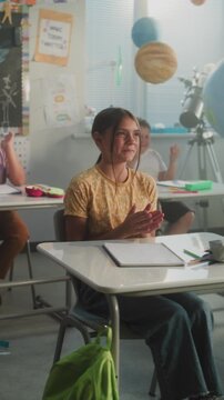 Cheerful Diverse Kids Clapping Their Hands, Interacting with Teacher During Dynamic Gamified Activity. Female Teacher Providing Interactive Lesson to Elementary School Students. Vertical Shot.