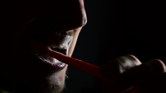 Healthy teeth and fresh mouth.
Eliminate bad breath and germs in the mouth with a toothbrush and toothpaste in a dark bathroom.
Morning bathroom routine