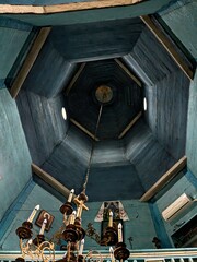 blue ceiling of a wooden church with a painting in the center