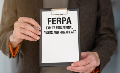 A person holding a clipboard with the word FERPA FAMILY EDUCATIONAL RIGHTS AND PRIVACY ACT on it.