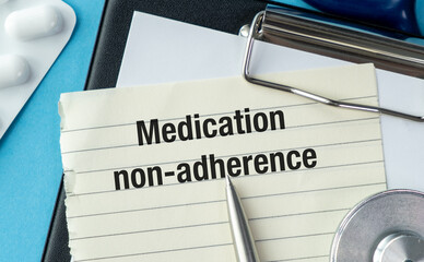 A piece of paper with the word Medication Non-adherence written on it. A pen is sitting on top of the paper