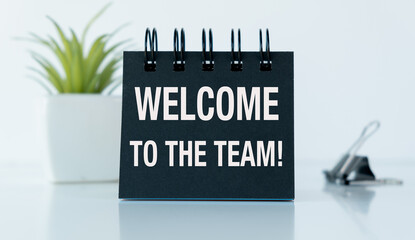 A black notebook with the words Welcome to the Team written on it