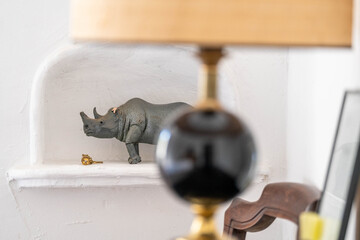 Artistic interior detail with decorative rhino figurine and blurred lamp in foreground — stylish...