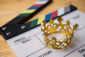 Close up golden crown on white clapperboard. Content is king strategy for video or live streaming...