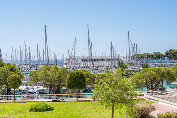 Obraz premium Scenic Marina with Sailboats and Green Park in Summer