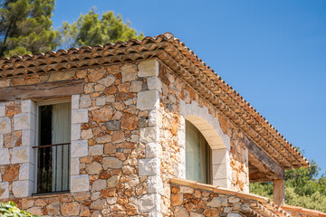 Traditional stone house with terracotta roof under a clear blue sky in the South of France, rustic architecture and Mediterranean charm