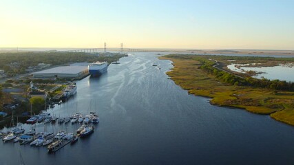 Aerial view of the majestic Sidney Lanier Bridge spans across the river, connecting verdant wetlands to industrial docks, Brunswick, Georgia, United States.