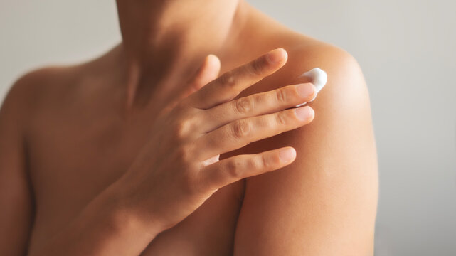 Woman applying body cream on arm, beauty skin care concept