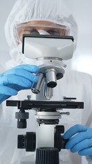 Male scientist virologist wearing hazmat suit, mask, and blue gloves, diligently working at a...