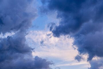  Large dark clouds cover light clouds in the sky close-up, dark swirling clouds like heavenly gates opening to light sky, sharp weather change