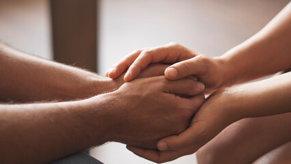 Closeup shot of two unrecognizable people holding hands in comfort