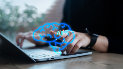 Close-up of a hand interacting with an AI brain hologram on a laptop, symbolizing artificial...