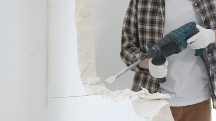 Close up of unrecognizable male construction worker wearing beige checkered shirt and protective...