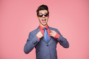 A vibrant individual dressed in a smart suit and tie, confidently smiling and showing...