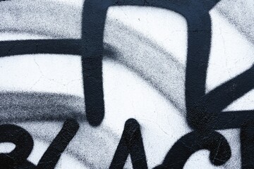 Monochrome graffiti with bold black lines on textured wall. Urban, street art, retro 90s, abstract...