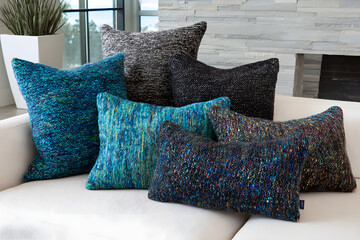 Assortment of decorative pillows in various colors and textures on a sofa.