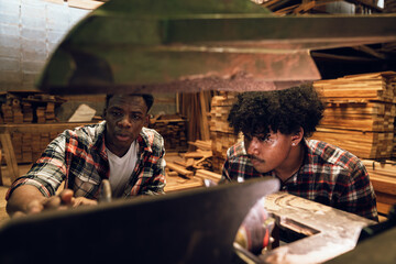 Factory Workers Discussing Work in Timber Sawmill, Two African American Men Collaborating in...