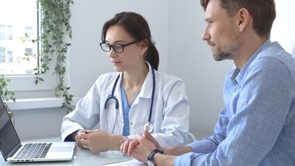 Female doctor explaining a diagnosis to a male patient, offering medical advice and support during...