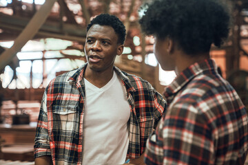 Factory Workers Discussing Work in Timber Sawmill, Two African American Men Collaborating in...