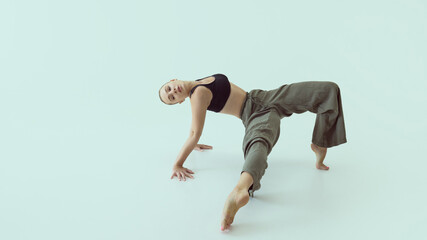 Dancer holding expressive floor pose with relaxed body and steady gaze in contemporary performance....