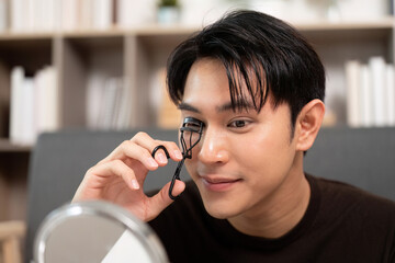 Grooming Routine. Male using eyelash curler for a polished look.