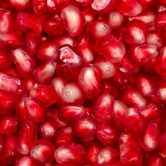 Red juicy pomegranate seeds close-up, isolated, square background