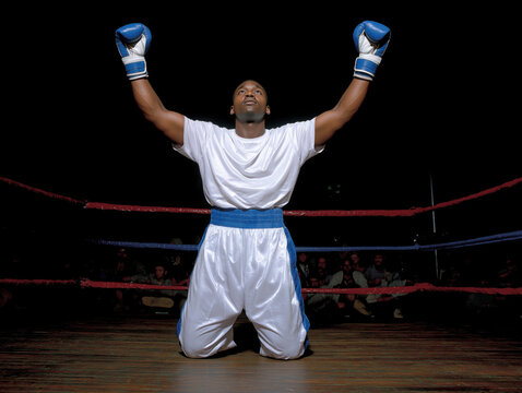 African American boxer kneeling in a ring with arms raised in victory, surrounded by cheering crowd, showcasing triumph and determination in the sport of boxing