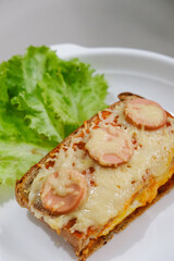 Homemade pizza made from white bread with sausage and cheese toppings
