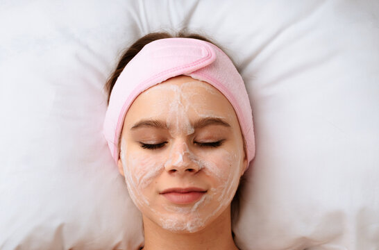 Woman relaxing with face bubble cleansing mask during skincare treatment in beauty salon