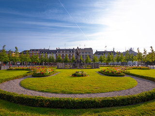 Kongens Nytorv, Copenhagen—lush gardens, historic buildings, and iconic statue under vivid skies....