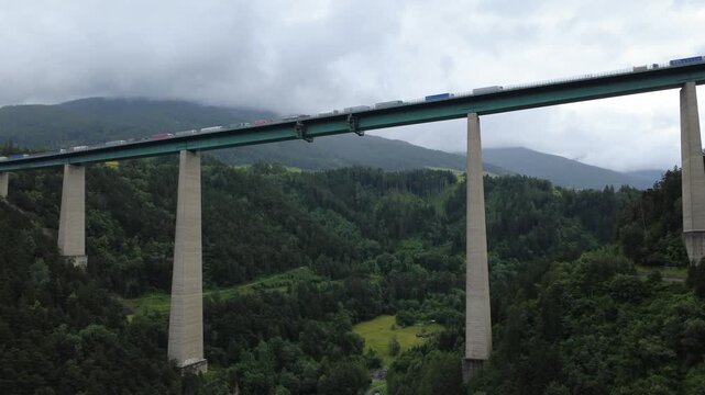Dramatic drone clip flying beneath the iconic Brenner Bridge in Tyrol. A rare angle showcasing engineering and mountain surroundings.