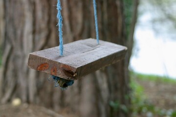 Close up of handmade wooden swing in woodland