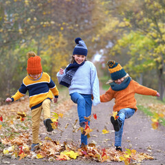 Leaf Kicking Joy: Kids Playing with Colorful Autumn Leaves