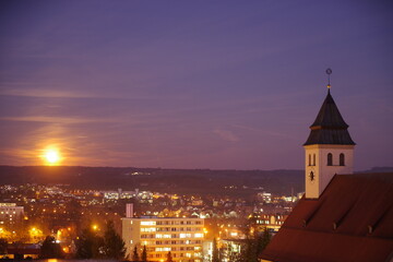 City at night with a large clock tower in the background