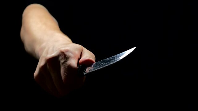 Aggressive Hulinag with a sharp knife in his hands close-up.
A man with a sharp metal knife in his hands.
A robber or criminal with a sharpened kitchen knife in his hands.
Self-defense against an atta