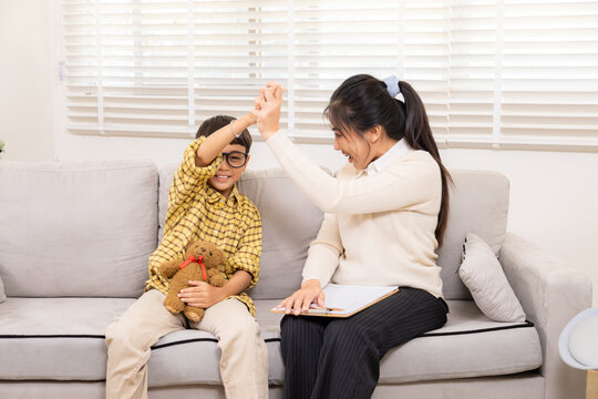 Therapy, child, counseling, psychologist, counselor joyful play with young boy smiling with bear on lap, sign of trust, emotional progress in positive healing session, happy cheerful interaction