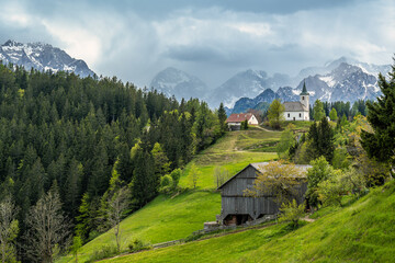 Mountain village with church and alpine landscape
